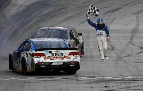 Kevin Harvick celebrates with the checkered flag after winning the NASCAR Sprint Cup Series race at Bristol Motor Speedwayin Bristol Tennessee