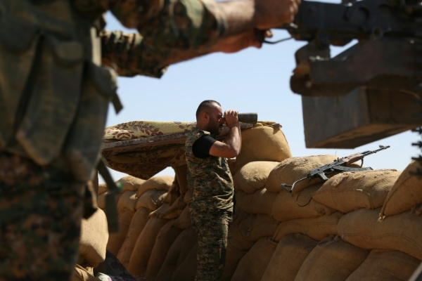 A fighter from the Kurdish People Protection Unit observes enemy activity on the front line in the northeastern Syrian city of Hasakeh on Sept. 4 2015