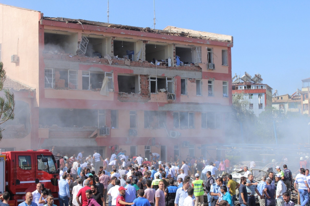 People rush to the blast scene after a car bomb attack on a police station in the eastern Turkish city of Elazig Turkey