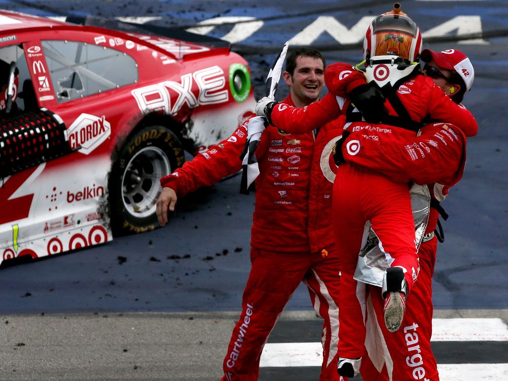 Kyle Larson driver of the #42 Target Chevrolet celebrates with crew members after winning the NASCAR Sprint Cup Series Pure Michigan 400 at Michigan International Speedway on Aug. 28 2016 in Brooklyn Mich