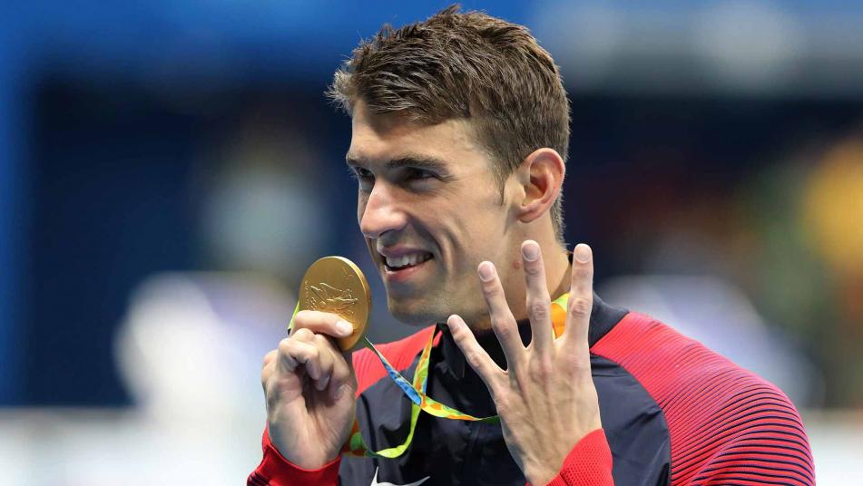 Michael Phelps holds up his 200m IM gold medal