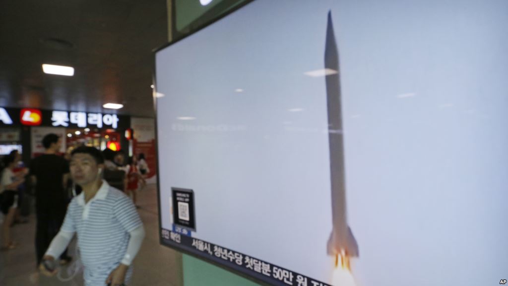 A man passes by a TV news program with file footage of a North Korean rocket launch at the Seoul Railway Station in Seoul South Korea Wednesday Aug. 3 2016