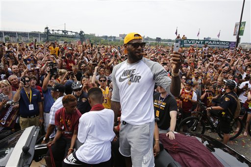 Cleveland Cavaliers&#039 Le Bron James center takes a selfie as he stands in the back of a Rolls Royce as it makes it way through the crowd lining the parade route in downtown Cleveland Wedensday