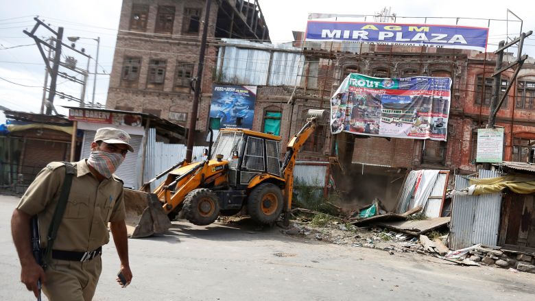 An Indian policeman patrols near the site after a gun fight between Indian Security Forces and suspected militants in Srinagar