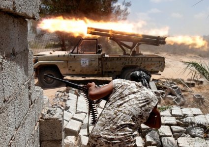 Libyan forces allied with the U.N.-backed government fire weapons during a battle with IS fighters in Sirte Libya