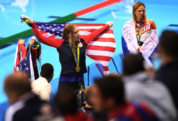 Lilly King stands atop the podium after taking home the gold in the 100-meter breaststroke