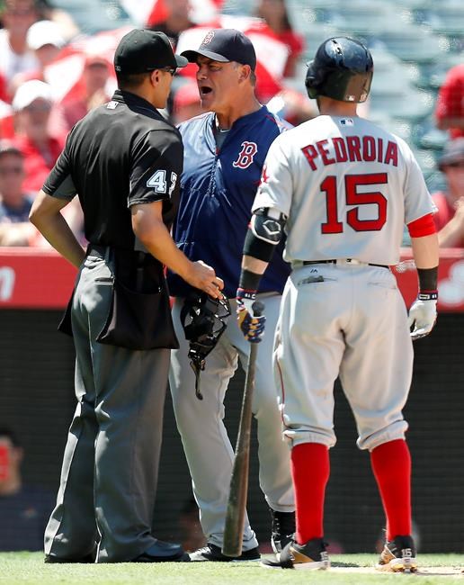 Boston Red Sox manager John Farrell middle yells at umpire Gabe Morales after Red Sox second baseman Dustin Pedroia right struck out during the fifth inning of a baseball game against the Los Angeles Angels Sunday