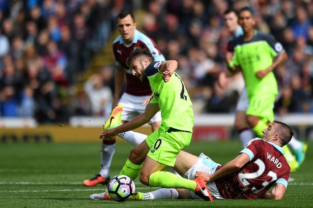 Liverpool's Adam Lallana an Burnley's Stephen Ward battle for the ball during the Premier League match at Turf Moor Burnley