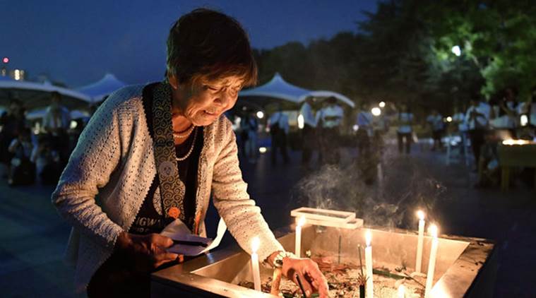 A woman lights up a candle in front of the cenotaph for the victims of the 1945 atomic bombing at Peace Memorial Park in Hiroshima western Japan in this