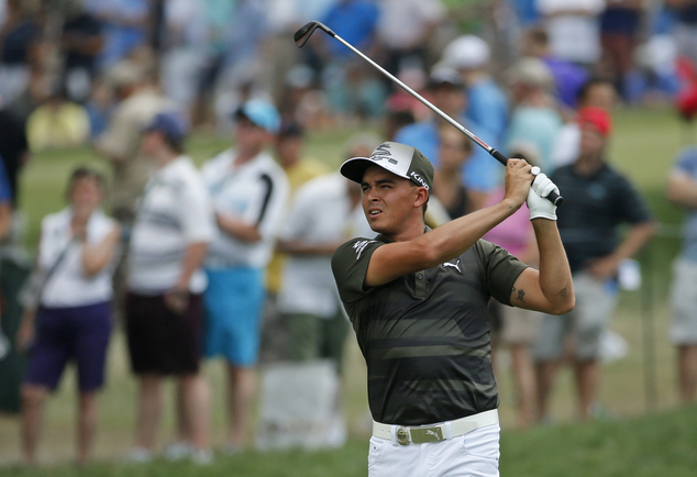 Rickie Fowler watches his approach shot to the first green during the third round of the PGA Championship golf tournament at Baltusrol Golf Club in Springfie