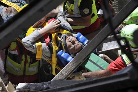 A man is rescued from the rubble of a building after an earthquake in Accumoli central Italy Wednesday Aug. 24 2016. A devastating earthquake rocked central Italy early Wednesday collapsing homes on top of residents as they slept. At least 23 people