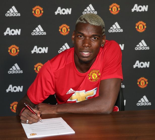 Paul Pogba poses after signing for Manchester United