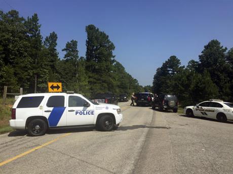 Law enforcement block an intersection during a stand off after two officers where shot in Sebastian County in Western Arkansas on Wednesday Aug. 10 2016. A man suspected of shooting and wounding the two law enforcement officers has been taken in into