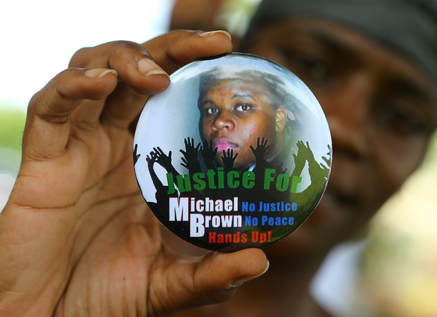 Nikki Jones of Spanish Lake Mo holds a button in support of Michael Brown while visiting the community in the apa