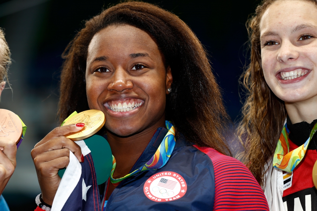 RIO DE JANEIRO BRAZIL- AUGUST 11 Gold medalist Simone Manuel of the United States celebrates during the medal ceremony for the Women's 100m Freestyle Final on Day 6 of the Rio 2016 Olympic Games at the Olympic Aquatics Stadium