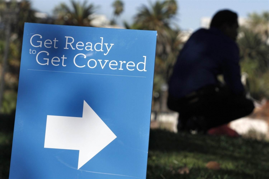 Image A man is silhouetted behind a sign at an Affordable Care Act outreach event hosted by Planned Parenthood for the Latino community in Los Angeles California