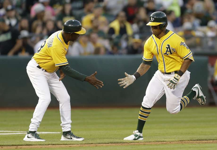 Oakland Athletics Khris Davis right celebrates with third base coach Ron Washington after hitting a home run against the Seattle Mariners in the sixth inning of a baseball game Saturday Aug. 13 2016 in Oakland Calif