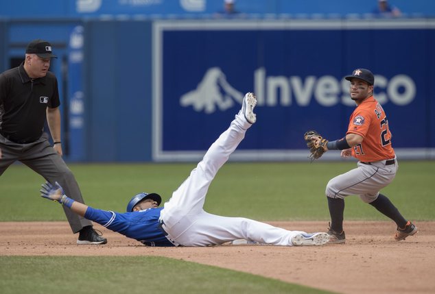 Toronto Blue Jays Edwin Encarnacion slides safely into second base with a double as Houston Astros Jose Altuve can't handle the throw in from center field