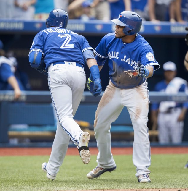 Toronto Blue Jays Troy Tulowitzki is congratulated by teammate Edwin Encarnacion after he hit a two-run home run to score Encarnacion during the fifth innin