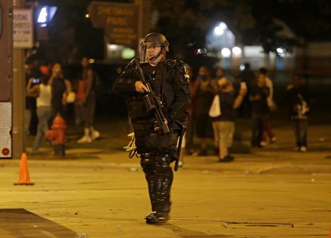 Police move in on people throwing rocks at police in Milwaukee Sunday Aug. 14 2016. Shots rang out during unrest after a police shooting that killed a man Saturday. Police said one person was shot at a Milwaukee protest on Sunday and officers used an