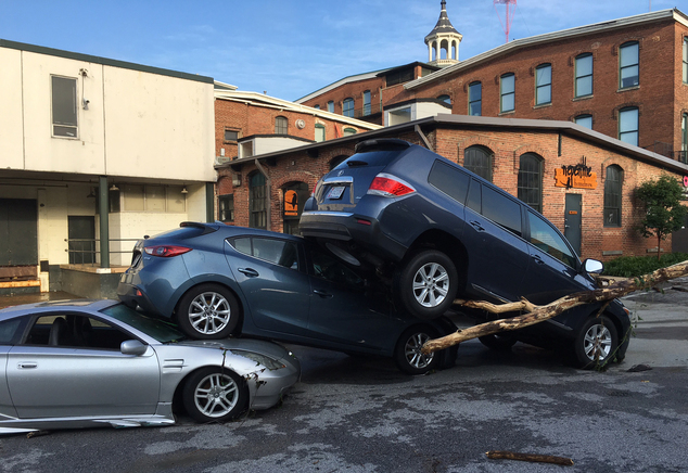 Cars are piled on top of each other in the Meadow Mill parking lot along the Jones Falls in Baltimore on Sunday