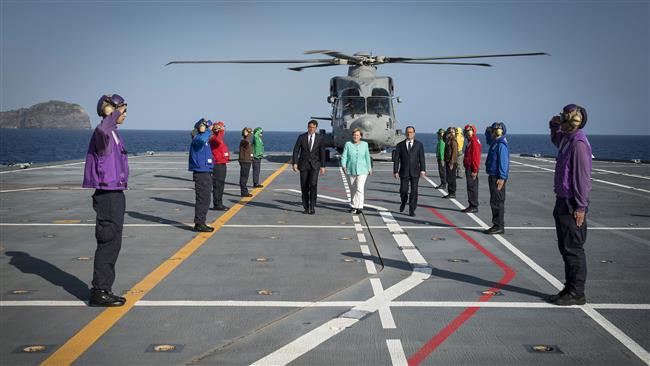 Italian Prime Minister Matteo Renzi, German Chancellor Angela Merkel and French President Francois Hollande arrive aboard an Italian aircraft carrier on the harbor of Italian island of Ventotene