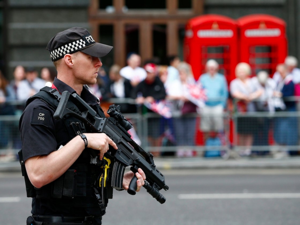 An armed police officer patrols ahead of the arrival of members of Britain's royal family to a service of thanksgiving for Queen Elizabeth's 90th birthday at St Paul's cathedral in London Britain