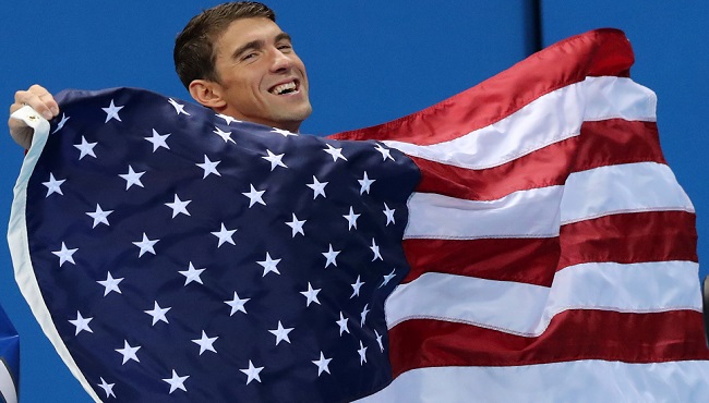 United States&#039 Michael Phelps walks with his national flag during the medal ceremony for the men's 4 x 100-meter medley relay final during the swimming competitions at the 2016 Summer Olympics Sunday Aug. 14 2016 in Rio de Janeiro Brazil