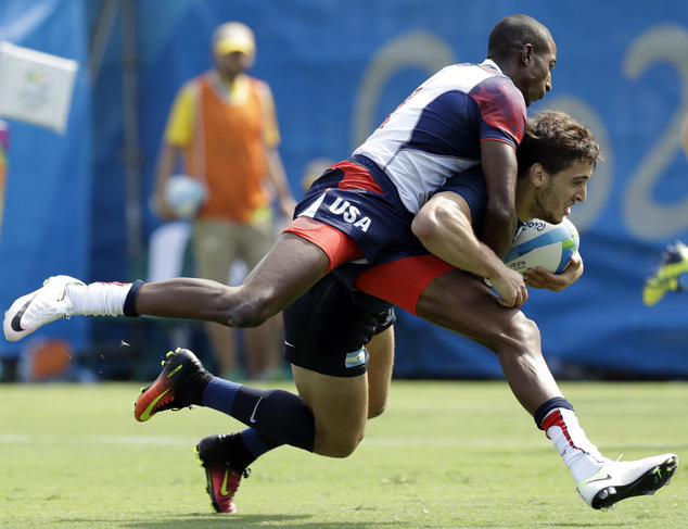 Argentina's Bautista Ezcurra front is tackled by United State's Perry Baker during the men's rugby sevens match at the Summer Olympics in Rio de Janeiro