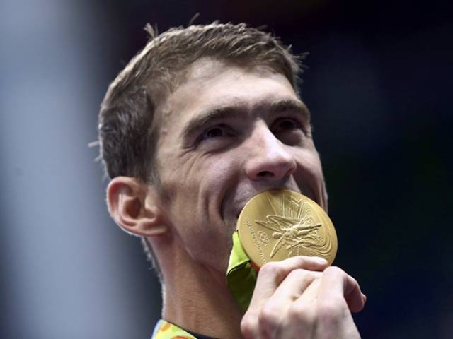 Michael Phelps poses with his gold medal