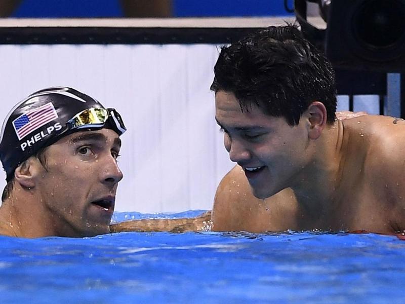 Michael Phelps talks with Joseph Schooling after the men's 100m butterfly final