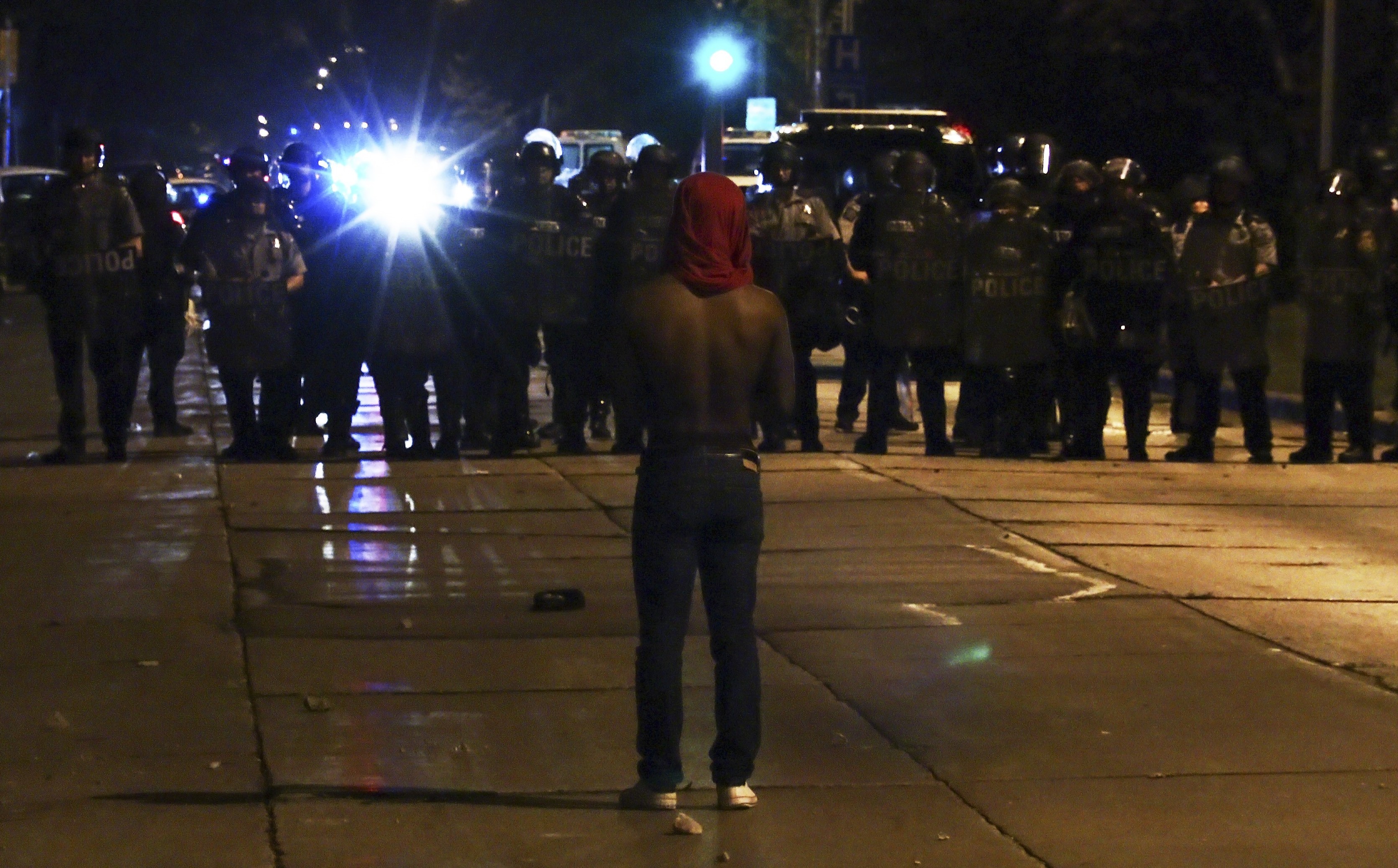 A protester faces police officers on Sunday in Milwaukee during a protest held for Sylville Smith who was shot and killed by a police officer as he reportedly attempted to flee during a traffic stop Saturday afternoon. (Bilgin S. Sasmaz Anadolu Agency