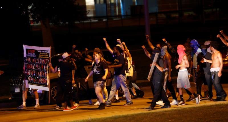 Protestors march toward police lines during disturbances following the police shooting of a man in Milwaukee Wisconsin