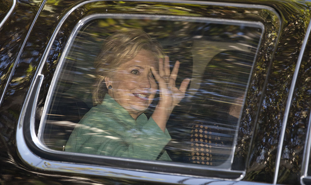 Democratic presidential candidate Hillary Clinton waves from her motorcade vehicle as she arrives for a fundraiser at the home of Justin Timberlake and Jessica Biel in Los Angeles Tuesday Aug. 23 2016