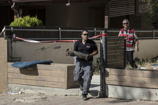 An Israeli police sapper carries part of a rocket which landed in a yard of a house in the city of Sderot southern Israel Sunday Aug. 21 2016. Palestinian militants in the Gaza Strip fired a rocket into southern Israel