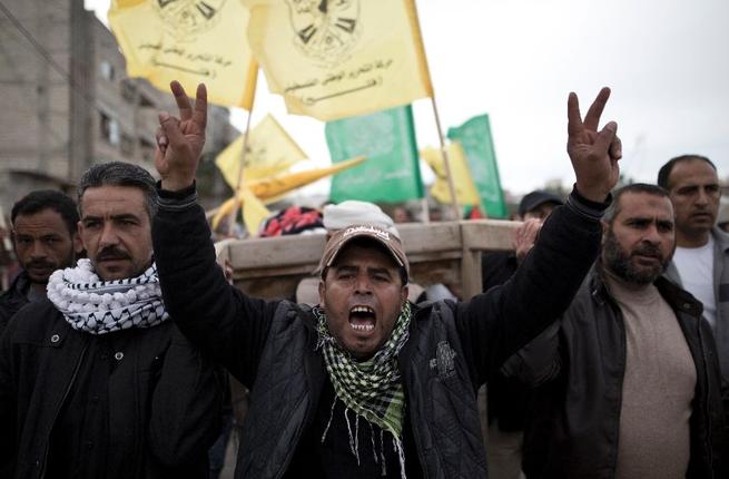 Palestinian mourners shout slogans as they carry the body of six-year-old Israa Abu Khussa during her funeral