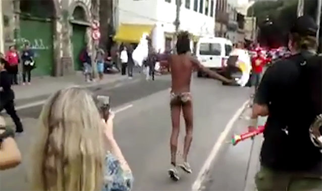 Musician Tarcisio Cisao makes the most of his torchbearering by baring his buttocks in protest