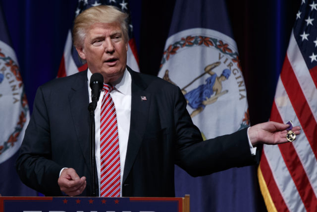 Republican presidential candidate Donald Trump holds a Purple Heart medal given to him by a supporter during a campaign rally at Briar Woods High School Tuesday Aug. 2 2016 in Ashburn Va