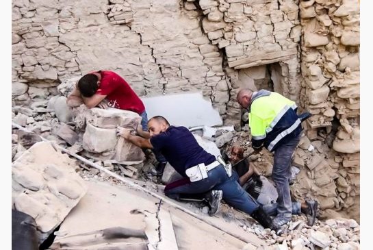 A man cries as another injured is helped in Amatrice central Italy where a 6.1 earthquake struck just after 3:30 a.m. Wednesday Aug. 24 2016. The quake was felt across a broad section of central Italy including the capital Rome where people in homes