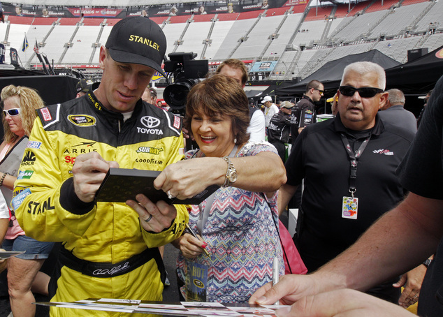 Carl Edwards signs an autograph as he walks through the pit area after practice for a NASCAR Sprint Series auto race on Friday Aug. 19 2016 in Bristol Ten