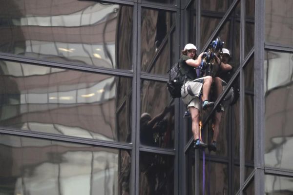 A man scales the all-glass facade of Trump