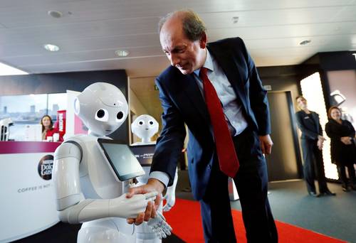 Nestle chief executive 0fficer Paul Bulcke shakes hands with a robot named