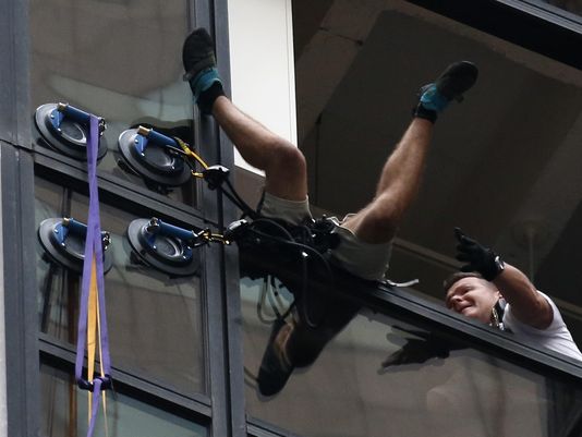 New York City police officers grab a man who climbed the Trump Tower on Aug. 10 2016