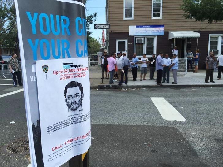 A sketch of a suspect in the shooting of Imam Maulama Akonjee 55 and Thara Uddin 64 hangs on a street sign across from Al Furqan Jame Mosque where the two victims had been worshipping on Saturday afternoon before the shooting in New York August 14