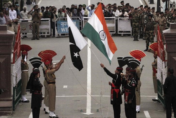 Pakistani rangers and Indian Border Security Force officers lower their national flags during a daily parade at the Pakistan India joint check-post at Wagah border near Lahore