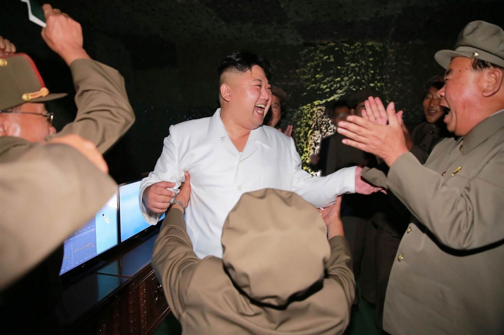 People watch a TV news program showing a file footage of North Korea's ballistic missile that the North claimed to have launched from underwater at Seoul Railway station in Seoul South Korea Saturday