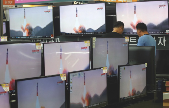 TV screens show a North Korean ballistic missile that Pyongyang claims to have launched from underwater at the Yongsan Electronic store in Seoul yesterday