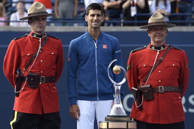 Novak Djokovic of Serbia poses alongside Mounties after his win over Kei Nishikori of Japan in the men's final of the Rogers Cup tennis tournament Sunda