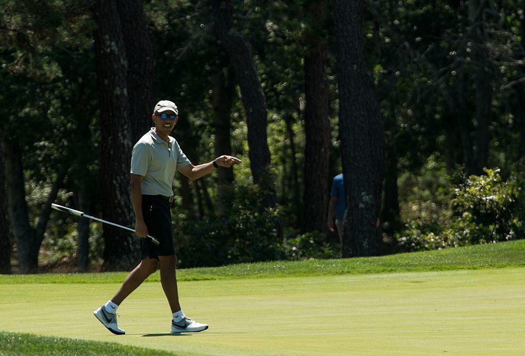 US President Barack Obama reacts to his putt on the first green as he plays golf at Farm Neck Golf Club in Oak Bluffs Massachusetts on the island of Martha's Vineyard