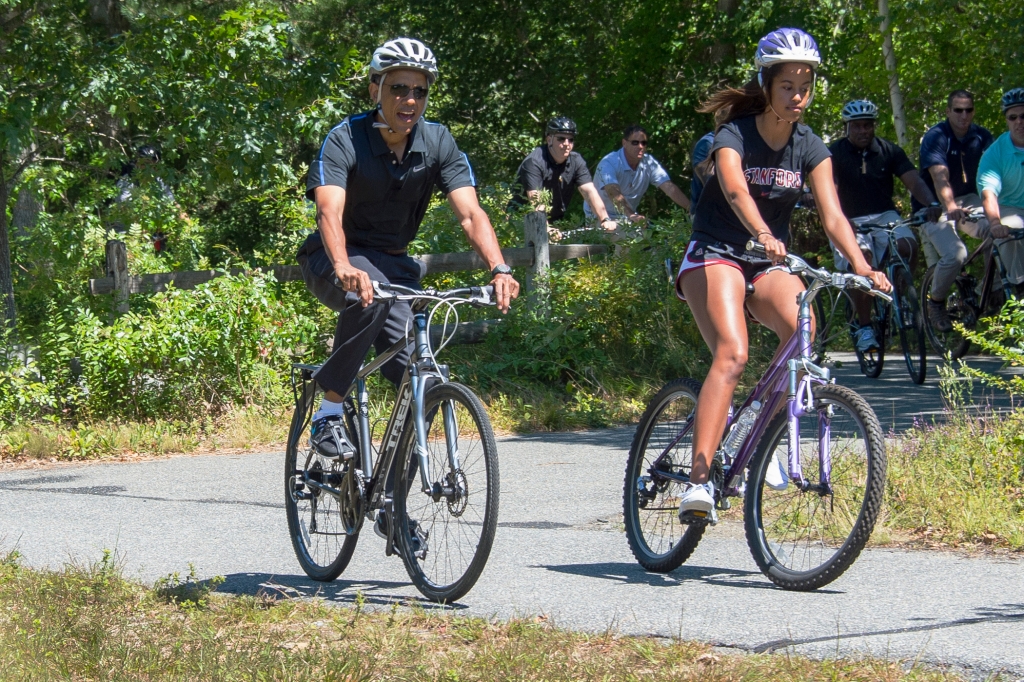 Aug. 15 2014 President Barack Obama and daughter Malia Obama ride bikes along the Correllus State Bike Path outside of West Tisbury Martha's Vineyard Mass